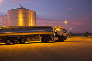 Milchtankwagen aus rostfreiem Stahl, der nachts neben dem Silageturm geparkt ist - CAIF17569