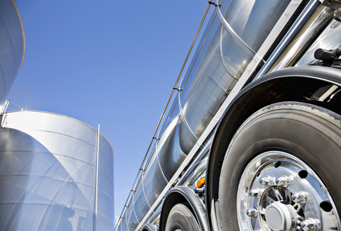 Milchtankwagen aus rostfreiem Stahl neben dem Silageturm geparkt, lizenzfreies Stockfoto