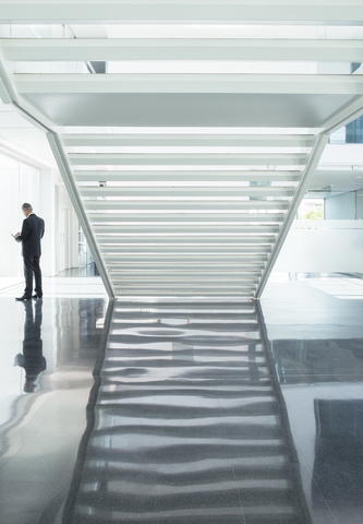 Geschäftsmann in moderner Lobby, lizenzfreies Stockfoto