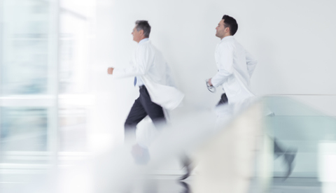 Ärzte laufen im Krankenhausflur, lizenzfreies Stockfoto