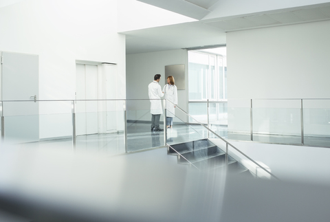 Ärzte im Gespräch auf dem Krankenhausflur, lizenzfreies Stockfoto