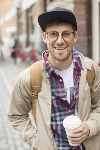 Mann mit Tasse Kaffee auf einer Straße in der Stadt, lizenzfreies Stockfoto