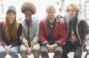 Friends smiling on urban bench - CAIF17667