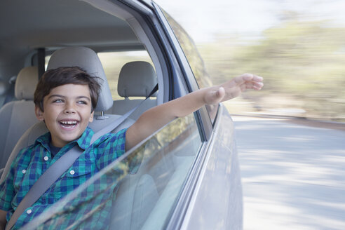 Glücklicher Junge streckt seine Hand aus dem Autofenster - CAIF17676