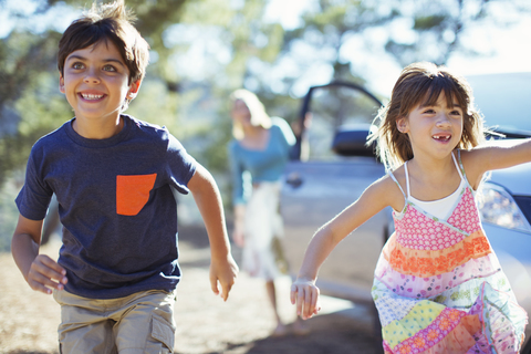 Glückliche Kinder, die aus dem Auto laufen, lizenzfreies Stockfoto