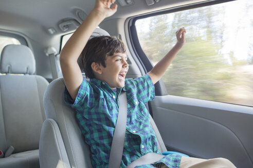Begeisterter Junge jubelt auf dem Rücksitz eines Autos - CAIF17678