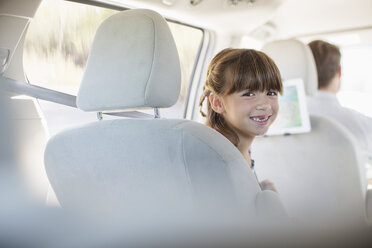 Porträt eines lächelnden Mädchens auf dem Rücksitz eines Autos - CAIF17685