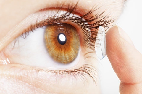 Extreme Nahaufnahme eines Mädchens, das eine Kontaktlinse ins Auge setzt, lizenzfreies Stockfoto