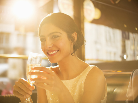 Gut gekleidete Frau trinkt Champagner im Restaurant, lizenzfreies Stockfoto
