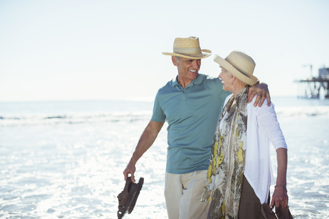 Älteres Paar geht am Strand spazieren, lizenzfreies Stockfoto