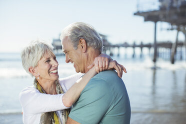 Älteres Paar umarmt sich am Strand - CAIF17743