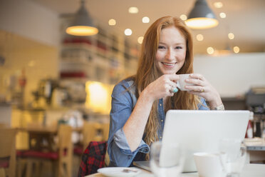Frau benutzt Laptop in einem Cafe - CAIF17753