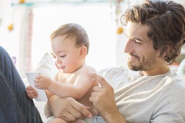 Father and baby boy playing with cell phone - CAIF17782