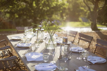 Bouquet and place settings on tranquil patio table - CAIF17851