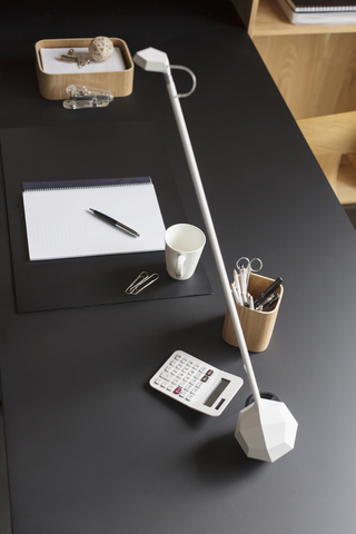 Objekte und moderne Lampe auf dem Schreibtisch im Heimbüro, lizenzfreies Stockfoto