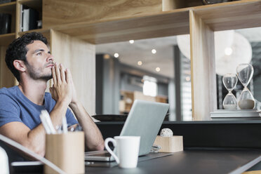 Pensive man at laptop in home office - CAIF17887