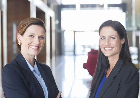 Lächelnde Geschäftsfrauen in der Lobby, lizenzfreies Stockfoto