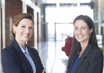 Businesswomen smiling in lobby - CAIF17915