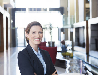 Businesswoman smiling in lobby - CAIF17921