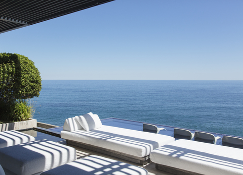 Sofas und Infinity-Pool mit Blick aufs Meer, lizenzfreies Stockfoto