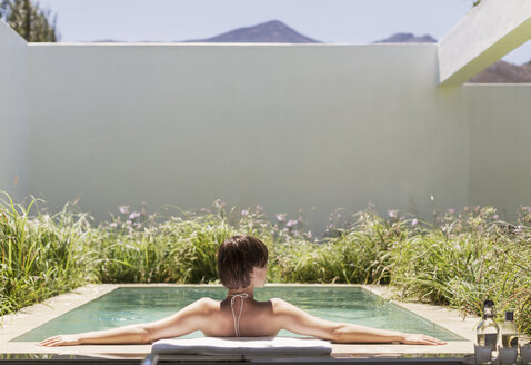 Frau entspannt sich im Luxus-Schwimmbecken - CAIF17964
