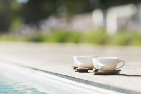 Cappuccinotassen am Pool, lizenzfreies Stockfoto