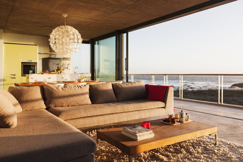 Sofa und Couchtisch im modernen Wohnzimmer mit Blick aufs Meer - CAIF17988