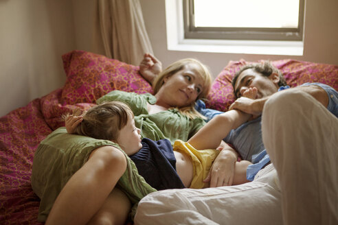 Familie auf dem Bett liegend zu Hause - CAVF09194