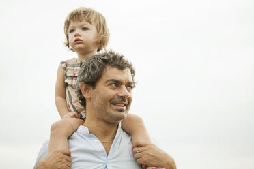 Father carrying daughter on shoulder at park - CAVF09225