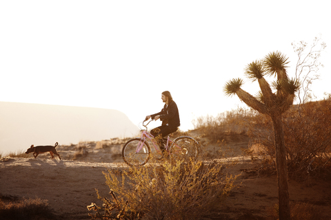 Seitenansicht eines Mannes beim Fahrradfahren auf einem Feld gegen den klaren Himmel, lizenzfreies Stockfoto