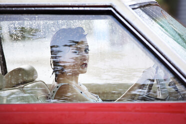 Porträt einer Frau, die das Lenkrad hält, während sie im Auto sitzt - CAVF09420
