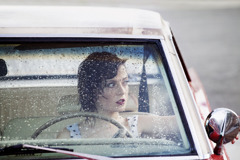 Woman looking through window while sitting in car stock photo