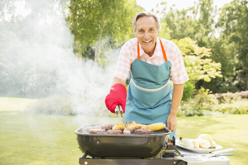 Mann grillt Essen auf dem Grill im Hinterhof - CAIF17997