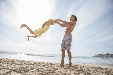 Father and daughter playing on beach - CAIF18046