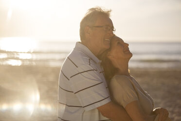 Älteres Paar umarmt sich am Strand - CAIF18048