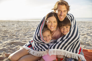 Familie in Decke eingewickelt am Strand - CAIF18050