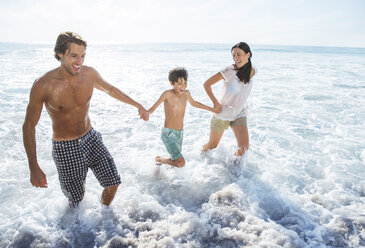 Family playing in waves at beach - CAIF18055