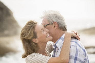 Older couple kissing on beach - CAIF18057