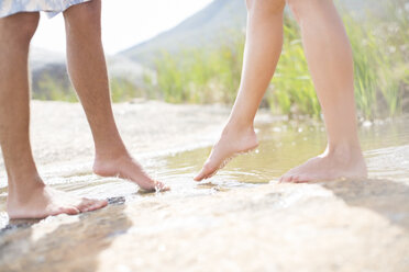 Couple dipping feet in rural pond - CAIF18070