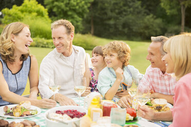 Mehrgenerationenfamilie beim Mittagessen im Garten - CAIF18096