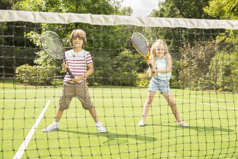 Kinder spielen Tennis auf einem Rasenplatz - CAIF18121