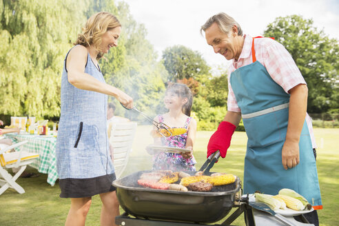 Mehrgenerationenfamilie beim Grillen im Hinterhof - CAIF18141