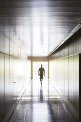 Silhouette of person walking in corridor - CAIF18165