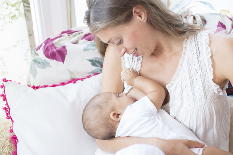 Mother breast-feeding baby boy stock photo