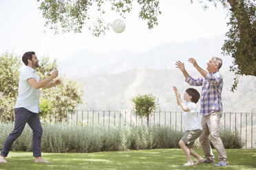 Multi-generation family playing volleyball in backyard - CAIF18235