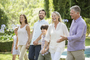 Mehrgenerationenfamilie beim Spaziergang im Hinterhof - CAIF18272