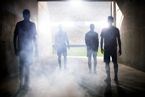 Silhouette von Fußballmannschaften vor dem Spielfeld, lizenzfreies Stockfoto