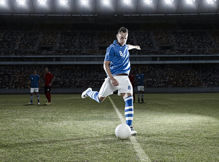 Fußballspieler, der den Ball auf dem Feld kickt - CAIF18349