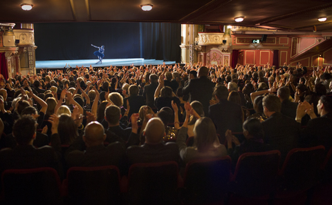 Publikum applaudiert einer Ballerina auf der Bühne eines Theaters, lizenzfreies Stockfoto