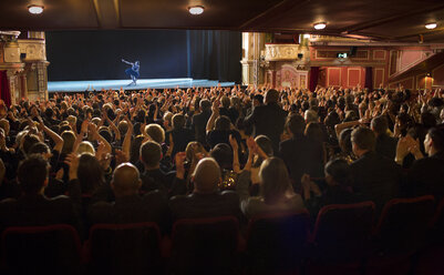 Audience applauding ballerina on stage in theater - CAIF18414